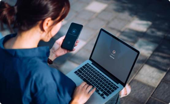 Femme utilisant un ordinateur et un smartphone dans la rue