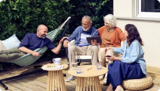 Un groupe de quatre amis sur un deck, profitant d'une tablette, tandis qu'un hamac les invite à se reposer.